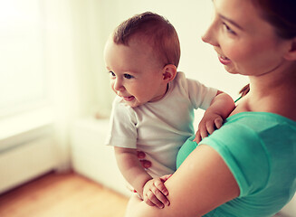 Image showing happy young mother with little baby at home