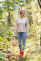 Image showing woman with basket picking mushrooms in forest