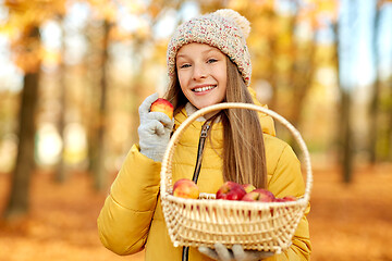 Image showing girl with apples in wicker basket at autumn park