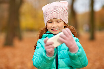 Image showing girl with smartphone at autumn park