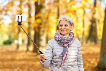 Image showing senior woman taking selfie at autumn park