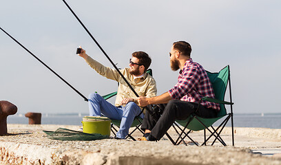 Image showing friends fishing and taking selfie by smartphone