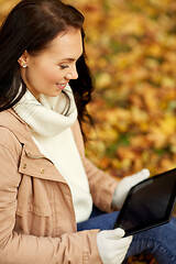 Image showing woman with tablet computer at autumn park