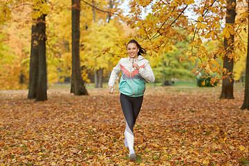 Image showing woman running in park and listening to music