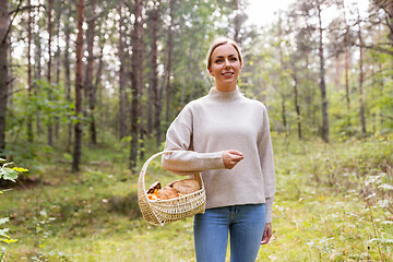 Image showing woman with basket picking mushrooms in forest