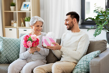 Image showing son giving present and flowers to senior mother