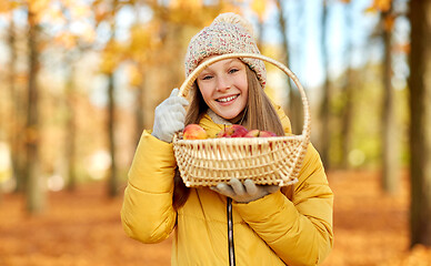 Image showing girl with apples in wicker basket at autumn park