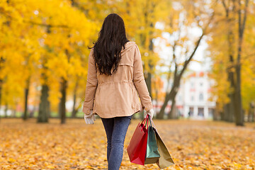 Image showing woman with shopping bags walking along autumn park