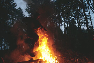 Image showing Soldier in Action at Night jumping over fire