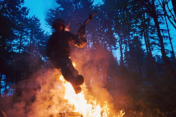 Image showing Soldier in Action at Night jumping over fire