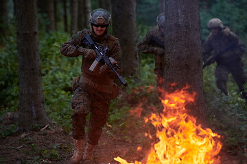 Image showing Soldier in Action at Night jumping over fire