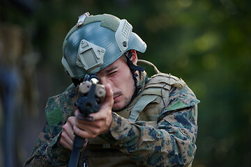 Image showing soldier in action aiming  on weapon  laser sight optics