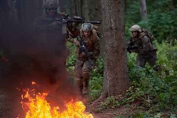 Image showing Soldier in Action at Night jumping over fire