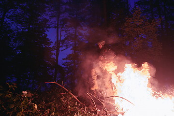 Image showing Soldier in Action at Night jumping over fire