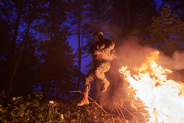 Image showing Soldier in Action at Night jumping over fire