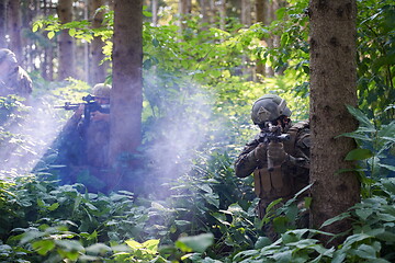 Image showing soldier in action aiming  on weapon  laser sight optics