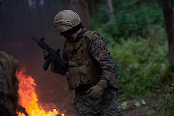 Image showing Soldier in Action at Night jumping over fire