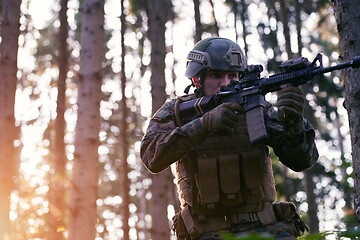 Image showing soldier in action aiming  on weapon  laser sight optics