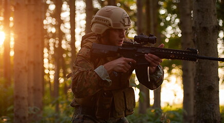 Image showing soldier in action aiming  on weapon  laser sight optics