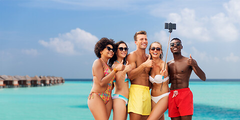 Image showing friends taking selfie on beach and show thumbs up