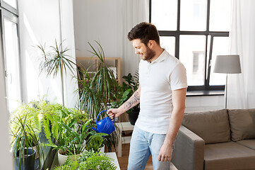 Image showing man watering houseplants at home