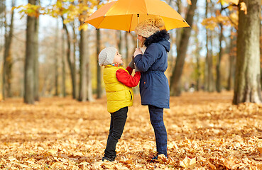 Image showing happy children with umbrella at autumn park