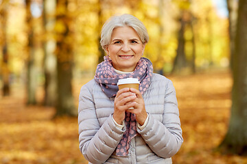 Image showing senior woman drinking coffee in autumn park