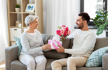 Image showing son giving present and flowers to senior mother