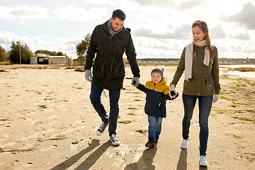 Image showing happy family walking along autumn beach