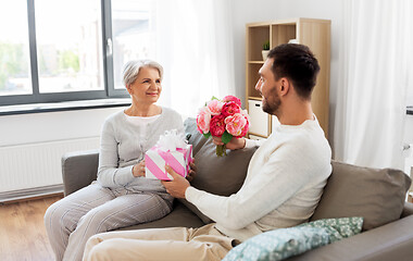 Image showing son giving present and flowers to senior mother