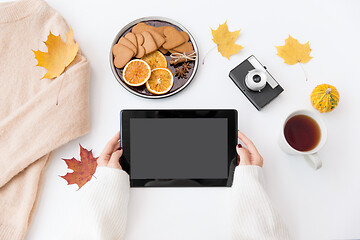 Image showing hands with tablet pc, tea and autumn leaves