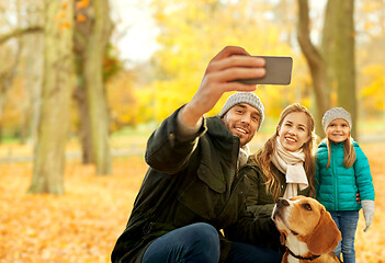 Image showing happy family with dog taking selfie in autumn park