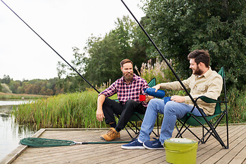 Image showing friends fishing and drinking tea from thermos