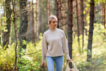 Image showing woman with basket picking mushrooms in forest