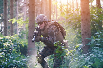 Image showing soldier in action aiming  on weapon  laser sight optics