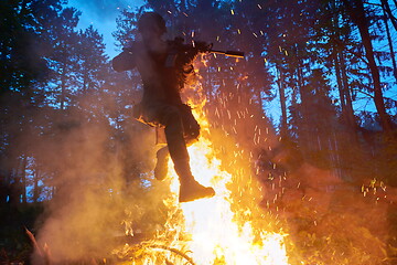 Image showing Soldier in Action at Night jumping over fire