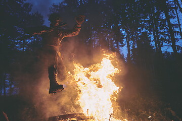 Image showing Soldier in Action at Night jumping over fire