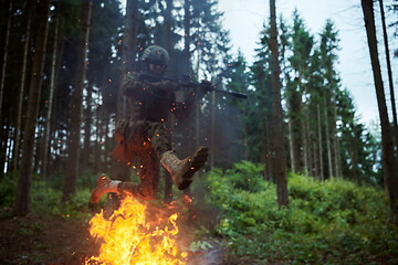 Image showing Soldier in Action at Night jumping over fire