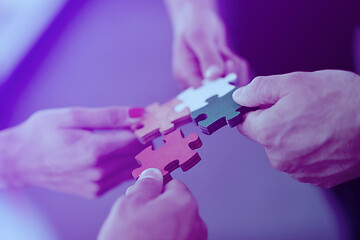 Image showing Group of business people assembling jigsaw puzzle