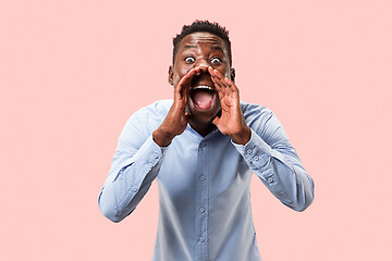 Image showing Isolated on pink young casual man shouting at studio