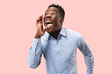 Image showing Isolated on pink young casual man shouting at studio