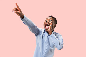 Image showing Isolated on pink young casual man shouting at studio