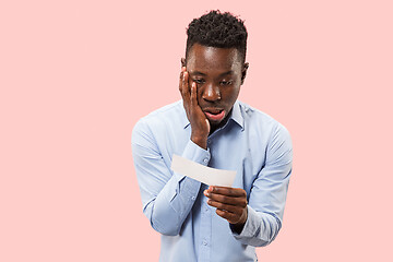 Image showing Young boy with a surprised expression bet slip on blue background