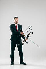 Image showing Businessman aiming at target with bow and arrow, isolated on white background