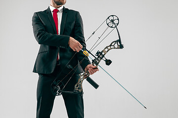 Image showing Businessman aiming at target with bow and arrow, isolated on white background