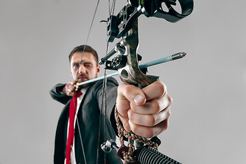 Image showing Businessman aiming at target with bow and arrow, isolated on white background