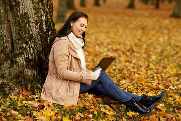 Image showing woman with tablet computer at autumn park