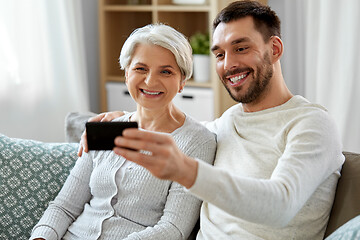 Image showing senior mother with adult son taking selfie at home