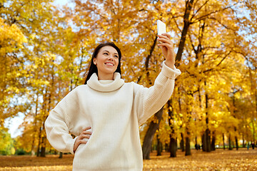 Image showing woman taking selfie by smartphone at autumn park