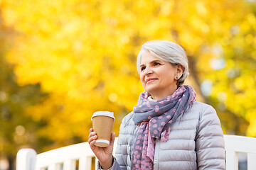 Image showing senior woman drinking coffee in autumn park